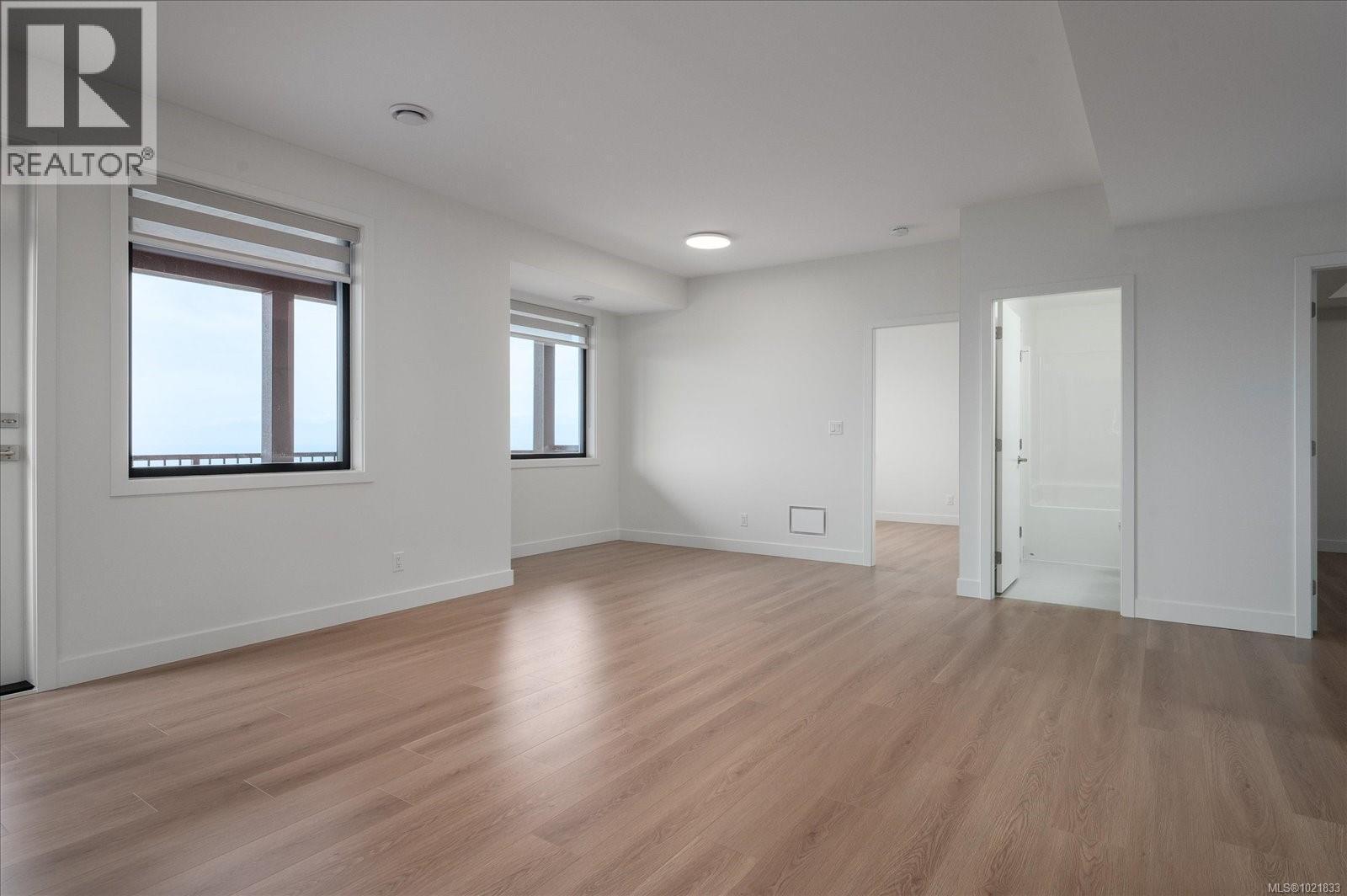 Empty room featuring baseboards and light wood-type flooring - 4680 Ambience Dr, Nanaimo, BC - Indoor Photo Showing Other Room