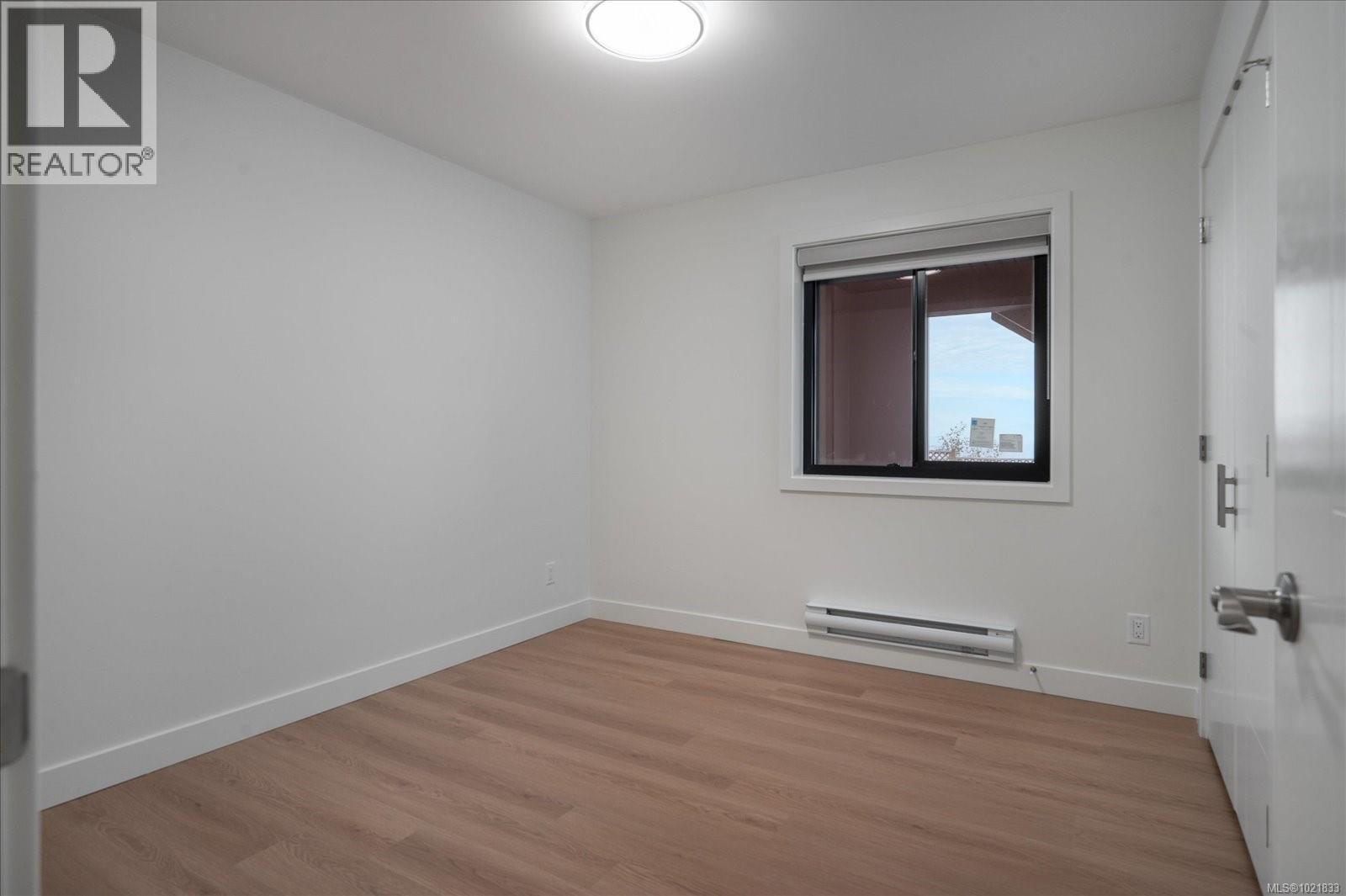 Unfurnished room with baseboard heating and light wood-style flooring - 4680 Ambience Dr, Nanaimo, BC - Indoor Photo Showing Other Room