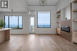 Unfurnished living room with a chandelier, crown molding, and light wood finished floors -