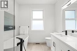 Ensuite with quartz counters and modern lighting and plumbing fixtures -