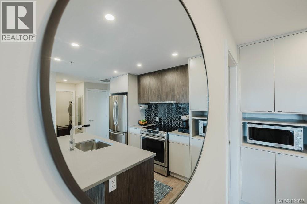 Kitchen featuring modern cabinets, stainless steel appliances, decorative backsplash, dark brown cabinets, and recessed lighting - 210 881 Short St, Saanich, BC - Indoor Photo Showing Kitchen With Stainless Steel Kitchen