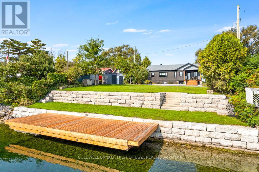 Tiered, superior retraining wall of armour stone - 38 Tuttle Point Road, Edwardsburgh/Cardinal, ON - Outdoor With Body Of Water