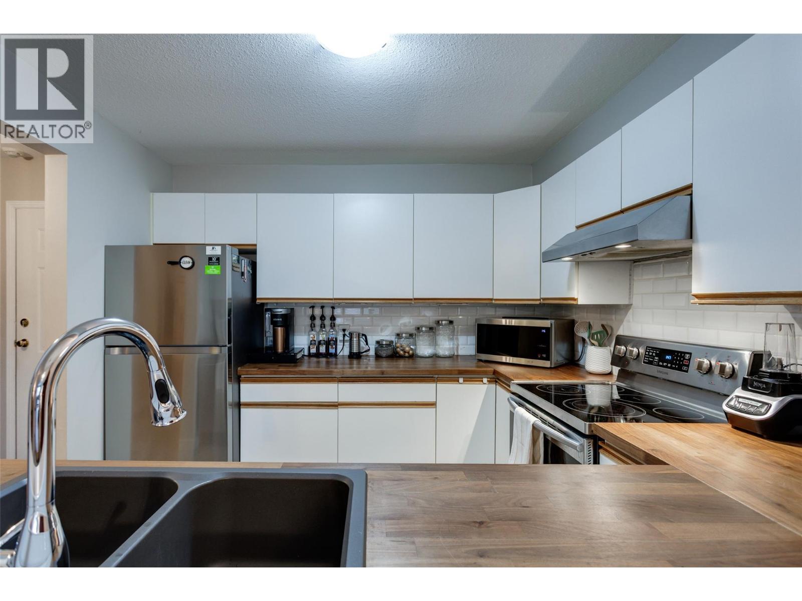 400 Sutton Crescent Unit# 110, Kelowna, BC - Indoor Photo Showing Kitchen With Stainless Steel Kitchen With Double Sink