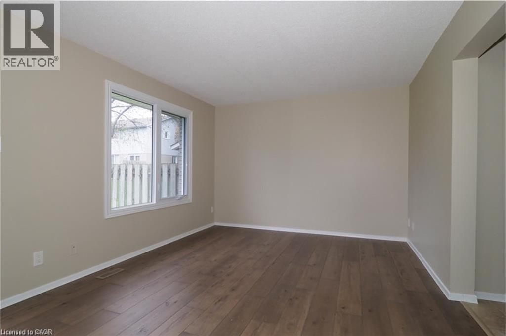 Spare room featuring baseboards and dark wood-type flooring - 455 Kingscourt Drive Unit# 3, Waterloo, ON - Indoor Photo Showing Other Room