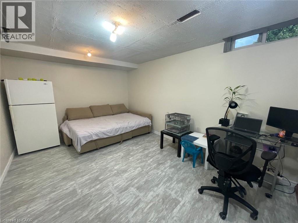 Bedroom with freestanding refrigerator, a desk, and a textured ceiling - 455 Kingscourt Drive Unit# 3, Waterloo, ON - Indoor