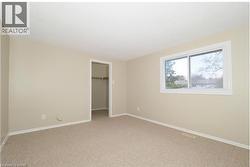 Unfurnished bedroom with a spacious closet and light carpet -