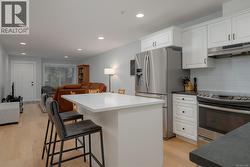 Kitchen with appliances with stainless steel finishes, and a breakfast bar -