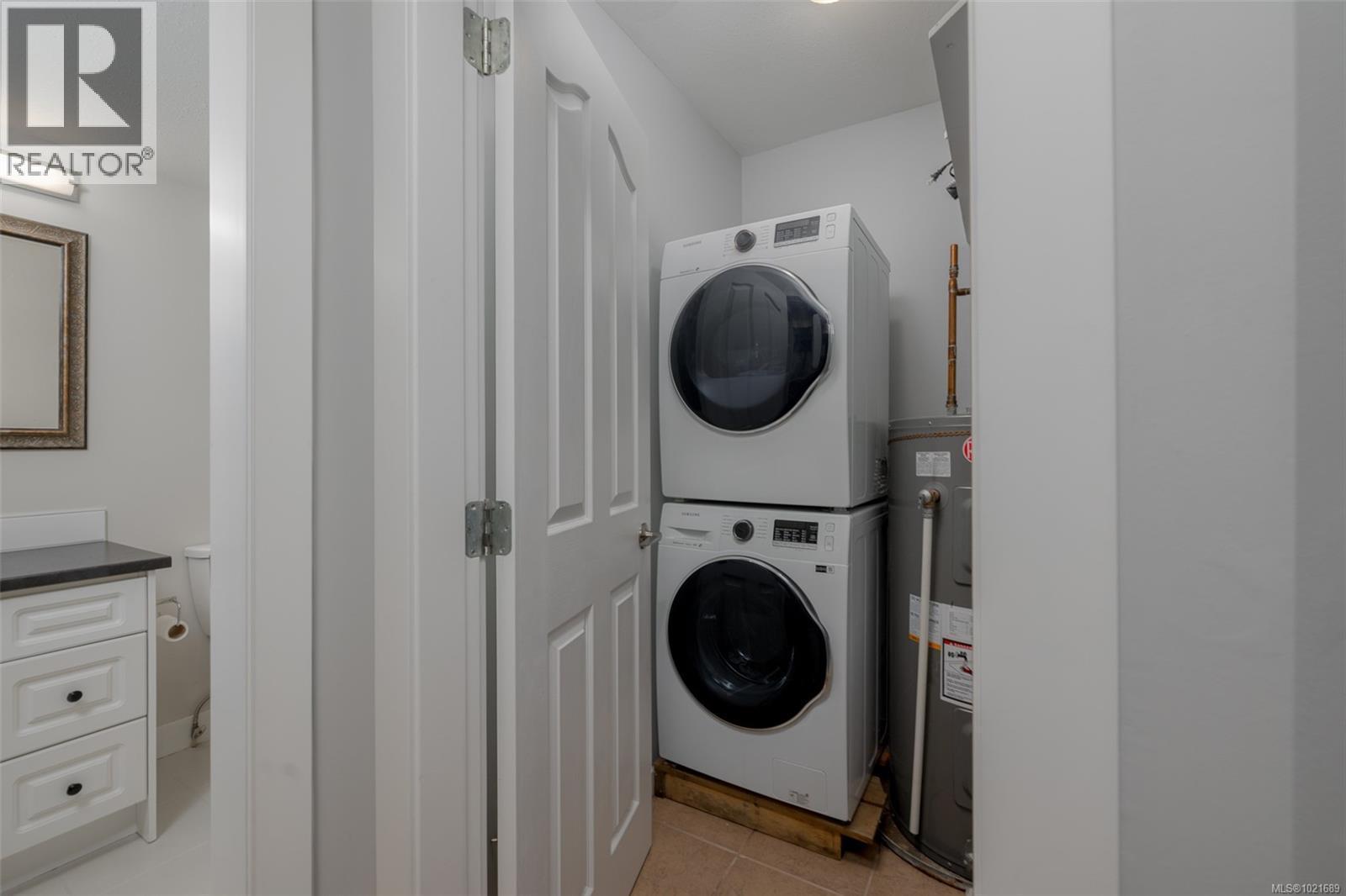 Laundry room with stacked washer / drying machine & electric water heater - 101 211 Victoria Rd, Nanaimo, BC