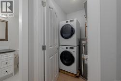 Laundry room with stacked washer / drying machine & electric water heater -