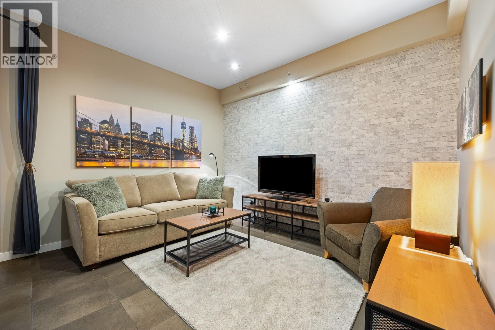 A Welcoming Den That Easily Transforms Into Your Media Room, Home Office, or Quiet Retreat - 1128 Sunset Drive Unit# 803, Kelowna, BC - Indoor Photo Showing Living Room