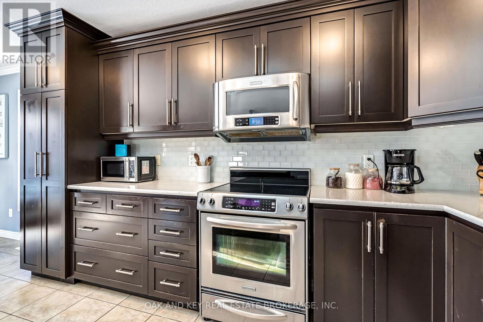 Glass Backsplash and large cupboards - 34 Fieldstone Crescent, Middlesex Centre (Komoka), ON - Indoor Photo Showing Kitchen
