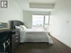 Bedroom with dark wood-style flooring and baseboards -