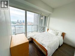 Bedroom with a city view and dark wood-type flooring -