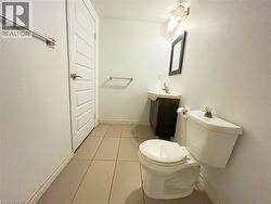 Half bath featuring vanity and light tile patterned floors -