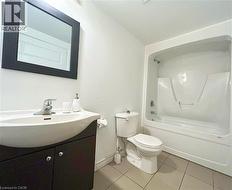 Full bath with vanity, shower / bathtub combination, and light tile patterned floors -