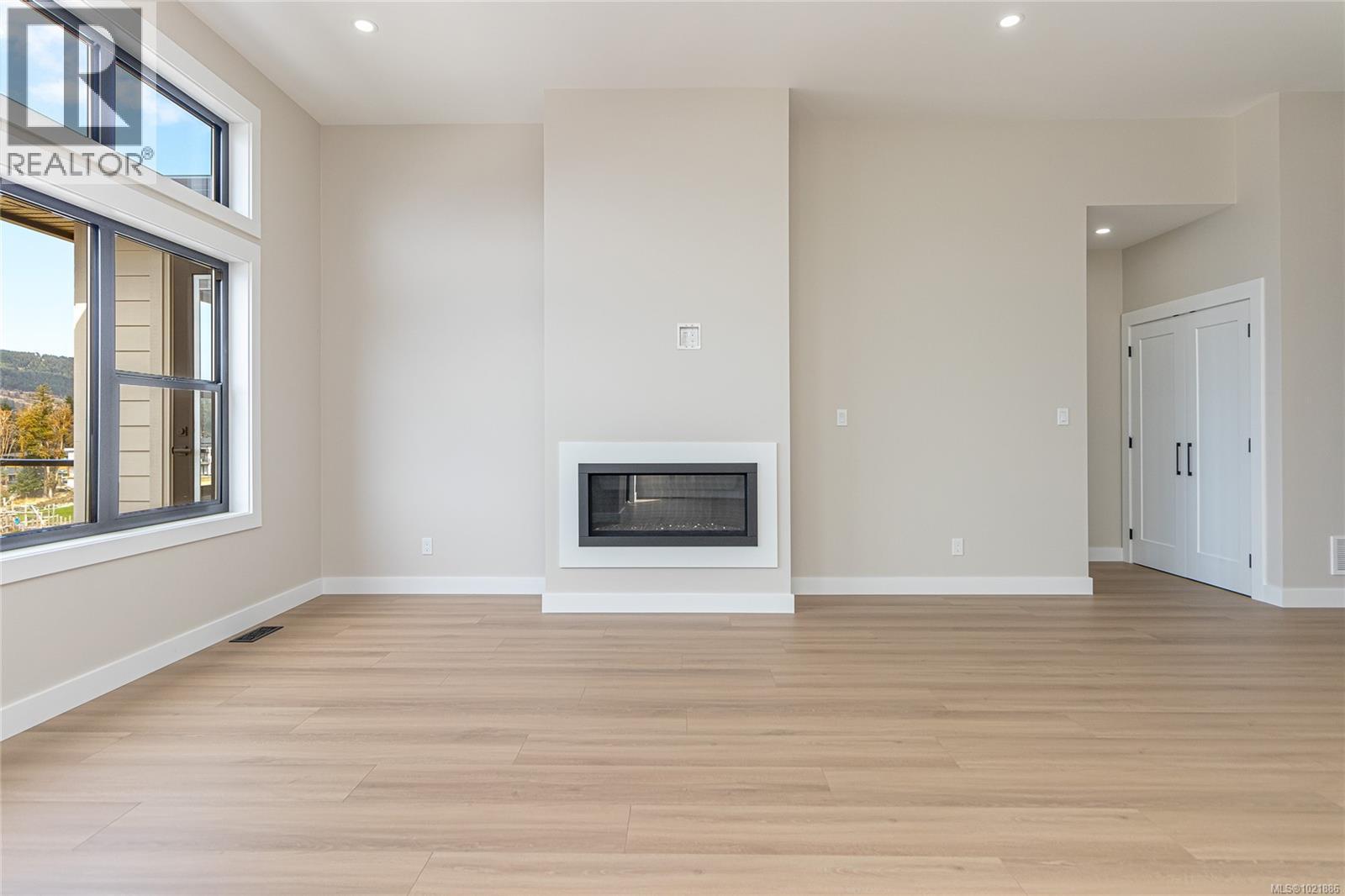 Unfurnished living room with a glass covered fireplace - 3195 Woodrush Dr, Duncan, BC - Indoor With Fireplace