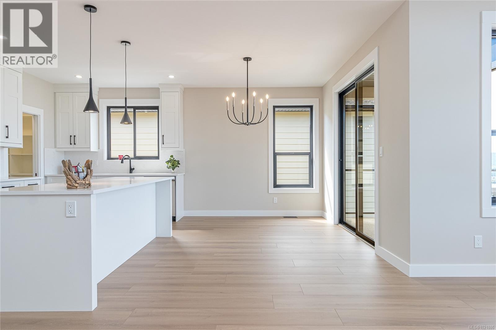 Kitchen with white cabinets, hanging light fixtures, a chandelier, plenty of natural light, and recessed lighting - 3195 Woodrush Dr, Duncan, BC - Indoor Photo Showing Kitchen