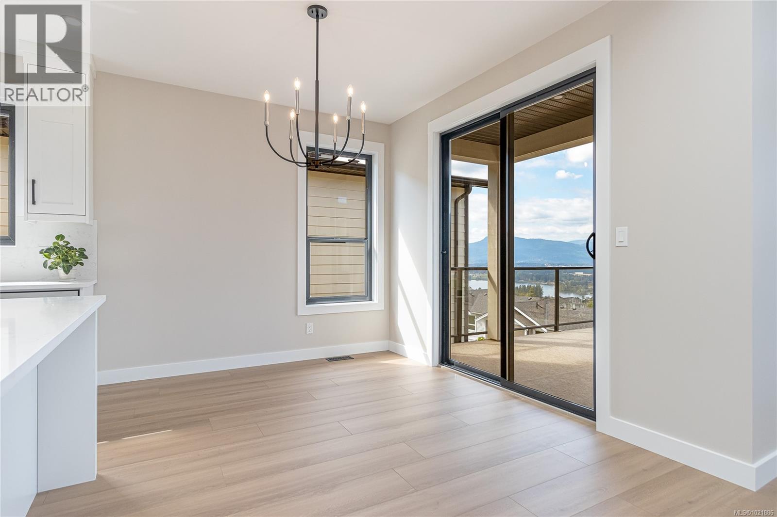 Unfurnished dining area featuring a chandelier, light wood finished floors, a mountain view, and recessed lighting - 3195 Woodrush Dr, Duncan, BC - Indoor Photo Showing Other Room