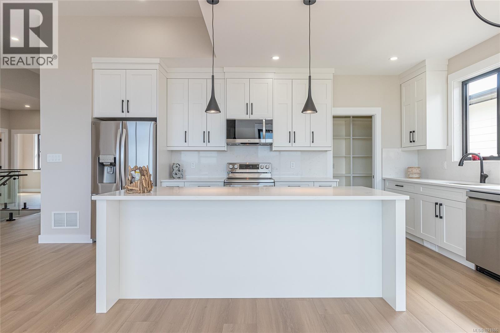 Kitchen with a kitchen island, backsplash, white cabinetry, decorative light fixtures, and recessed lighting - 3195 Woodrush Dr, Duncan, BC - Indoor Photo Showing Kitchen With Upgraded Kitchen