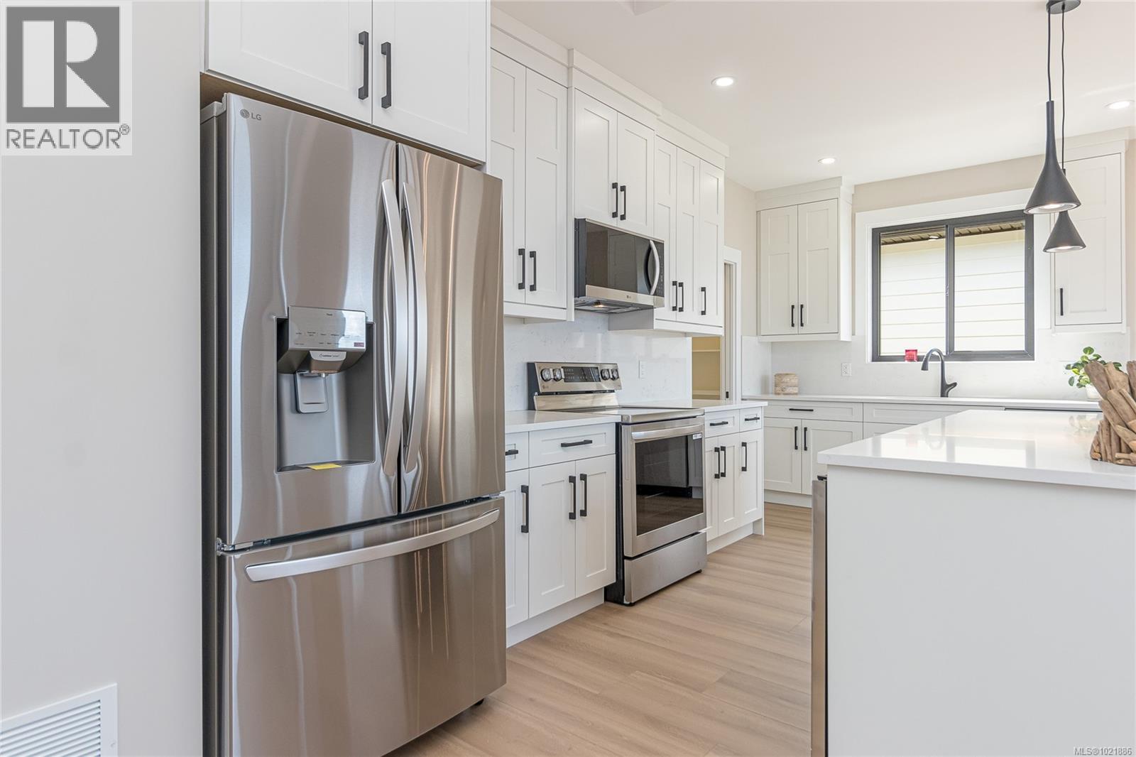 Kitchen with stainless steel appliances, hanging light fixtures, white cabi.nets - 3195 Woodrush Dr, Duncan, BC - Indoor Photo Showing Kitchen With Upgraded Kitchen