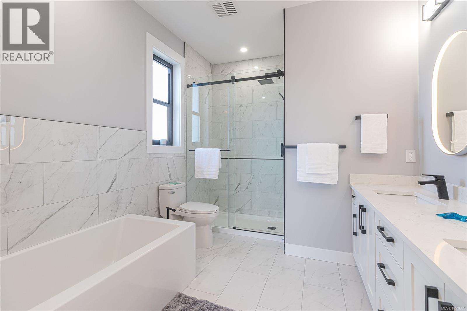 Bathroom featuring double vanity, a garden tub, a marble finish shower, light marble finish flooring, and tile walls - 3195 Woodrush Dr, Duncan, BC - Indoor Photo Showing Bathroom