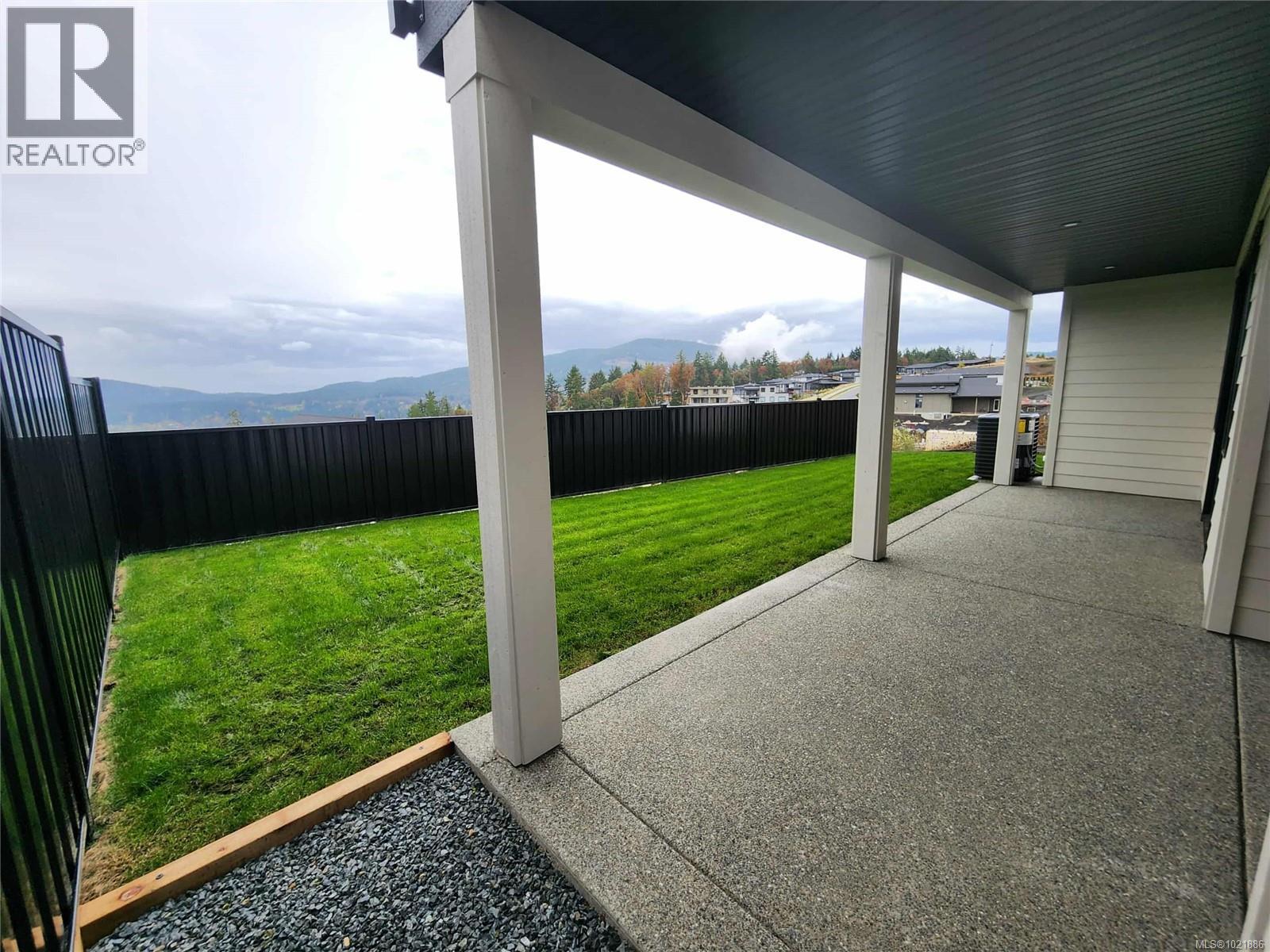 Fenced backyard featuring a patio area and a mountain view - 3195 Woodrush Dr, Duncan, BC - Outdoor With Exterior