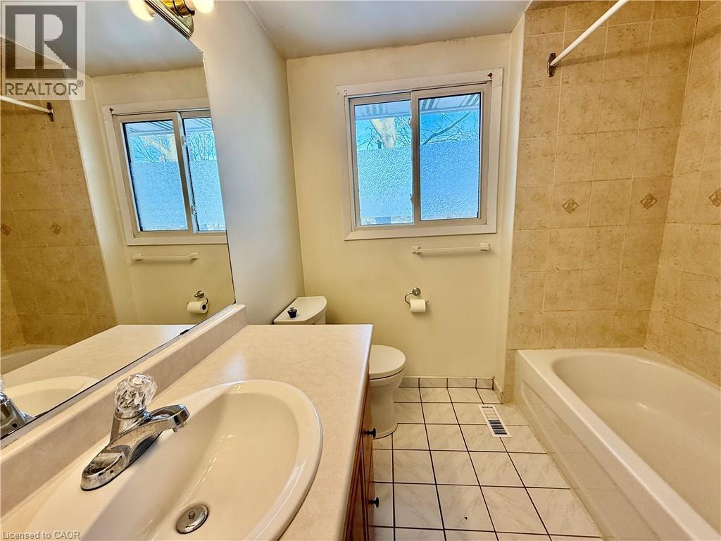 Full bathroom with vanity, shower / bathtub combination, light tile patterned floors, and plenty of natural light - 79 Lillian Drive Unit# A, Waterloo, ON - Indoor Photo Showing Bathroom