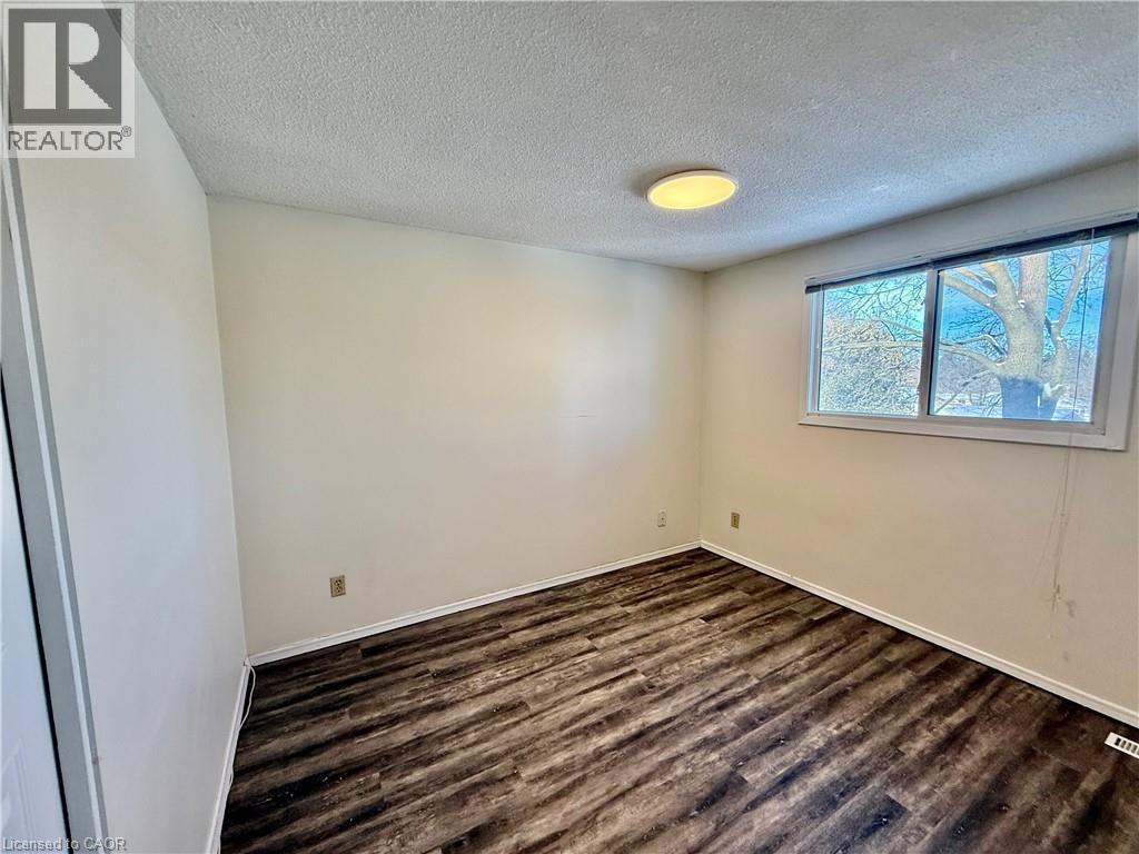 Spare room with a textured ceiling and dark wood finished floors - 79 Lillian Drive Unit# A, Waterloo, ON - Indoor Photo Showing Other Room