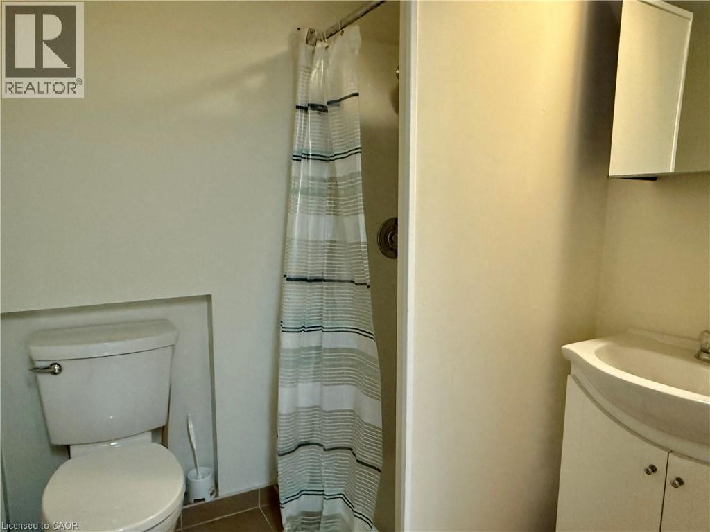 Full bath with a shower with shower curtain, vanity, and tile patterned flooring - 79 Lillian Drive Unit# A, Waterloo, ON - Indoor Photo Showing Bathroom