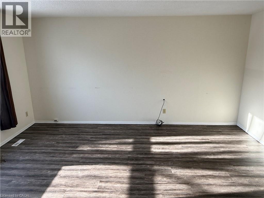 Spare room with dark wood-style floors and a textured ceiling - 79 Lillian Drive Unit# A, Waterloo, ON - Indoor Photo Showing Other Room