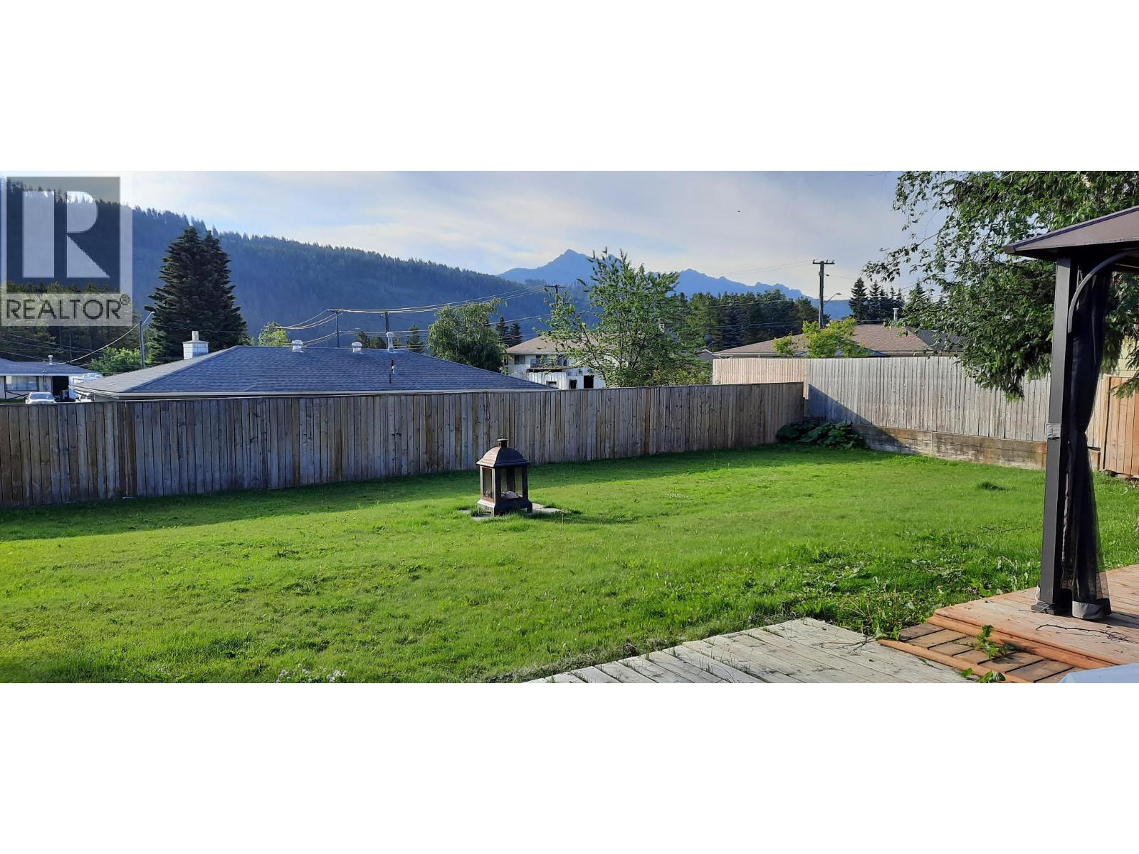 Photo of backyard from summer - 176 Cambourne Crescent, Elkford, BC - Outdoor With Backyard