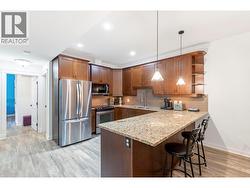 Open concept kitchen with granite counters, eat in bar, maple cabinets and new laminate floors -