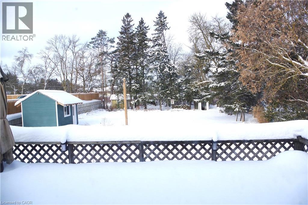 Yard covered in snow with an outbuilding and a deck - 425 Wellington Street E, Mount Forest, ON - Outdoor