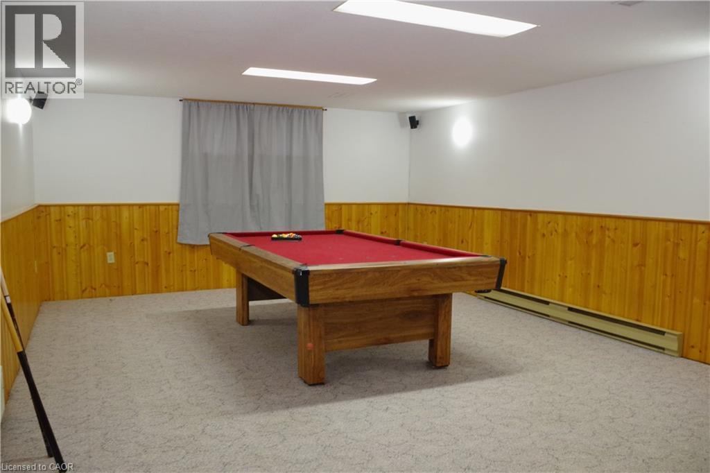 Game room with wood walls, wainscoting, baseboard heating, pool table, and carpet flooring - 425 Wellington Street E, Mount Forest, ON - Indoor Photo Showing Other Room