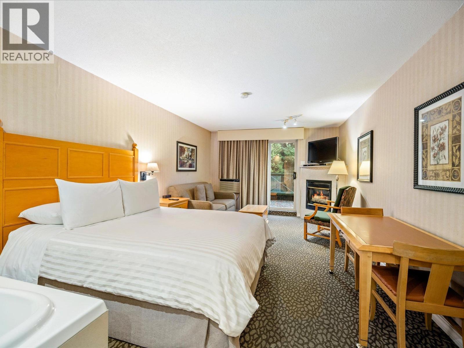 215 4319 Main Street, Whistler, BC - Indoor Photo Showing Bedroom With Fireplace