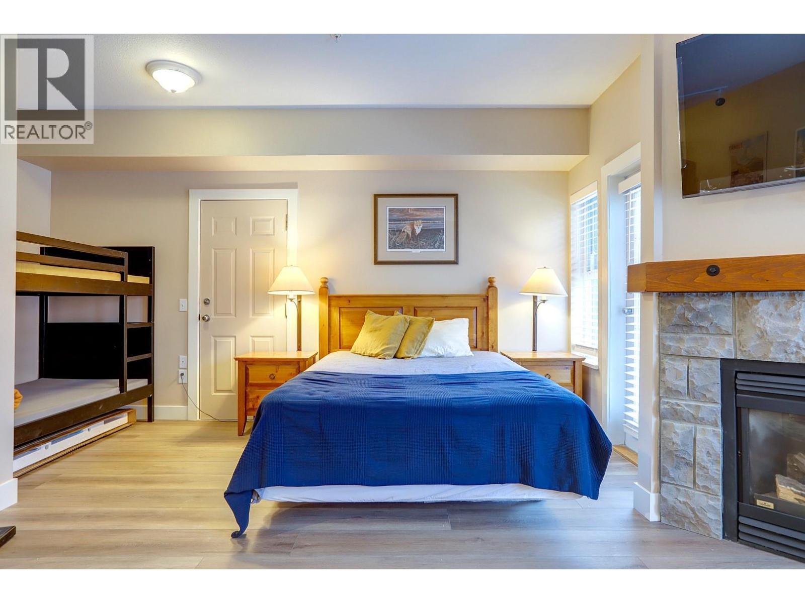 155 Silver Lode Lane Unit# 456, Silver Star, BC - Indoor Photo Showing Bedroom With Fireplace