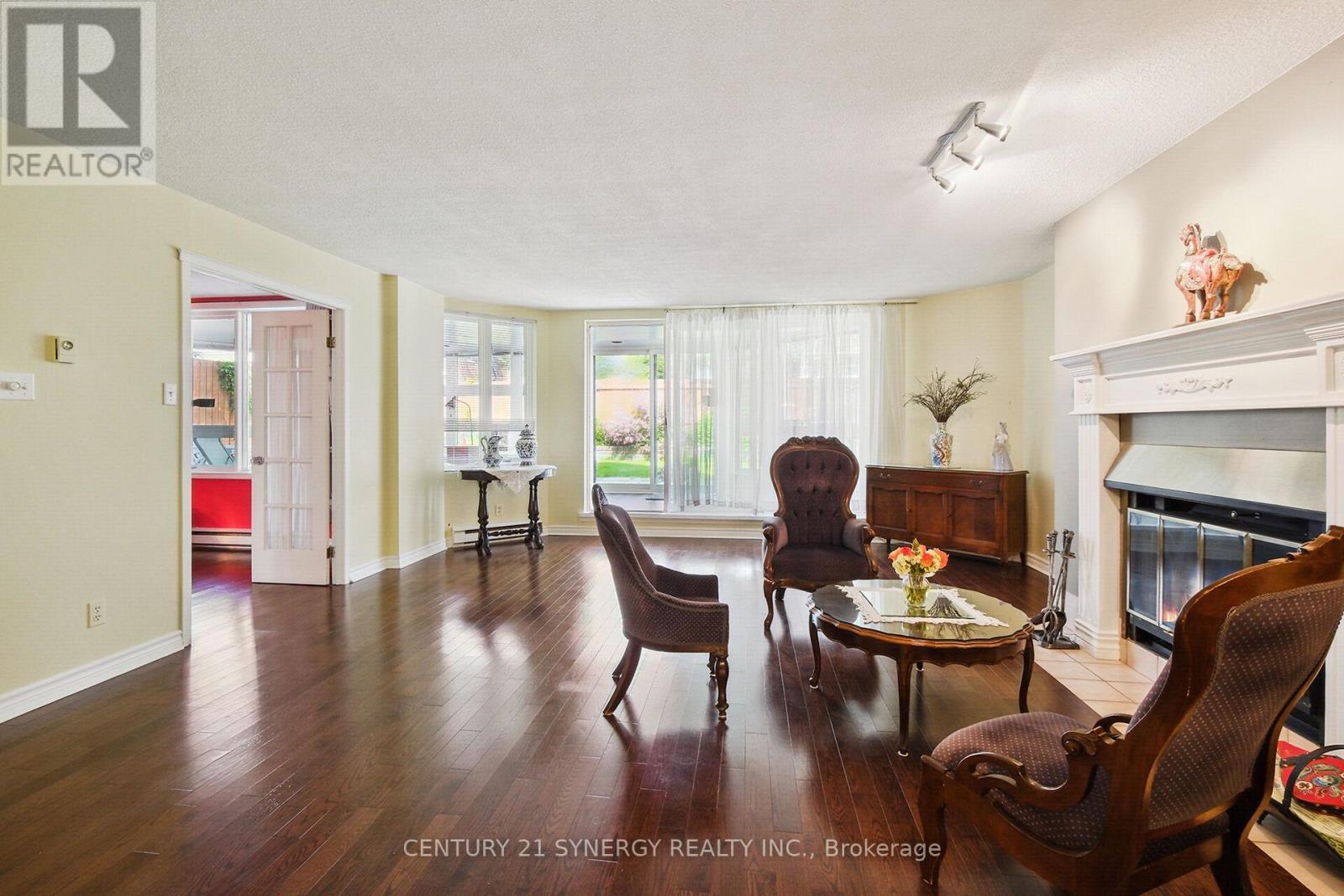 Exit out to the 4 season solarium - 104 - 295 Gilmour Street, Ottawa, ON - Indoor Photo Showing Living Room With Fireplace