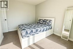 Carpeted bedroom featuring baseboards and lofted ceiling -