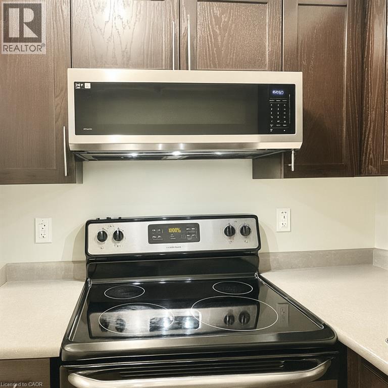 Kitchen view of appliances with stainless steel finishes, light countertops, and dark brown cabinets - 185 Windale Crescent Unit# 5A, Kitchener, ON - Indoor Photo Showing Kitchen