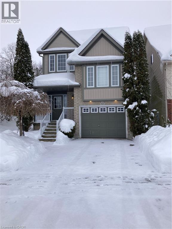 View of front facade with a garage and brick siding - 421 White Birch Avenue, Waterloo, ON - Outdoor With Facade