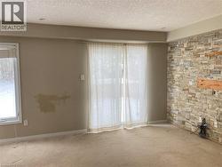 Unfurnished room featuring a textured ceiling and carpet -