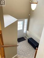 Foyer featuring light tile patterned floors and baseboards -