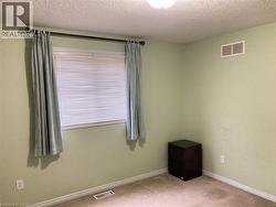 Spare room featuring a textured ceiling and light carpet -