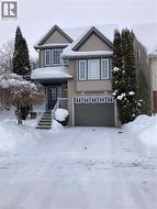 View of front facade with a garage and brick siding -