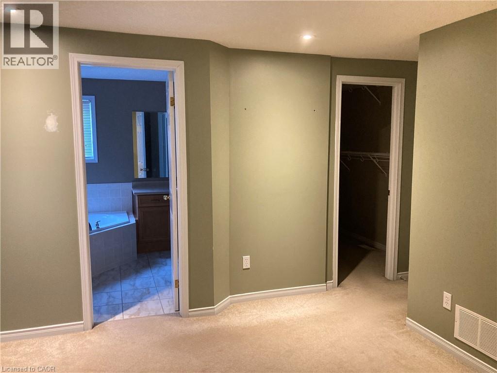 Unfurnished bedroom with light carpet, a spacious closet, recessed lighting, and ensuite bathroom - 421 White Birch Avenue, Waterloo, ON - Indoor