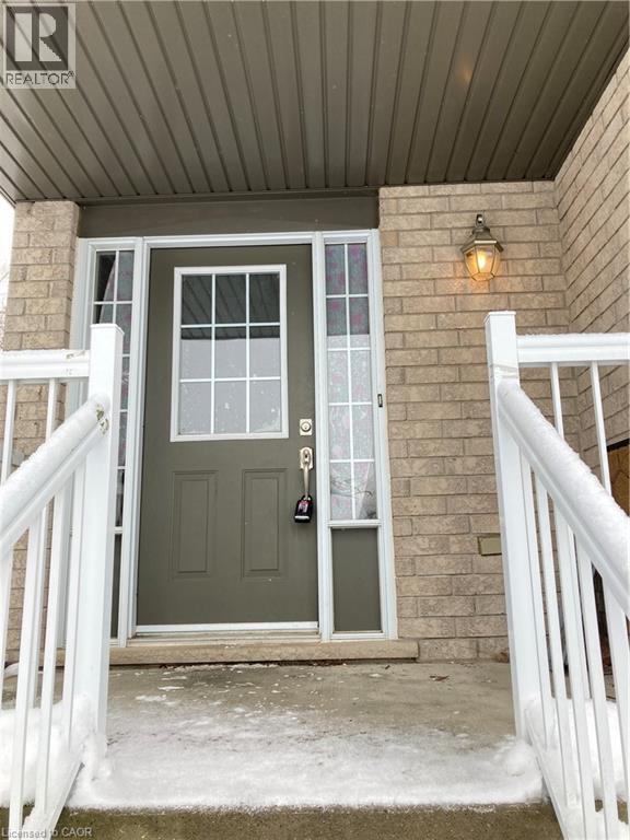 Doorway to property featuring brick siding and covered porch - 421 White Birch Avenue, Waterloo, ON - Outdoor With Exterior