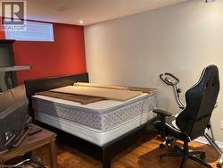 Bedroom with wood finished floors and recessed lighting -