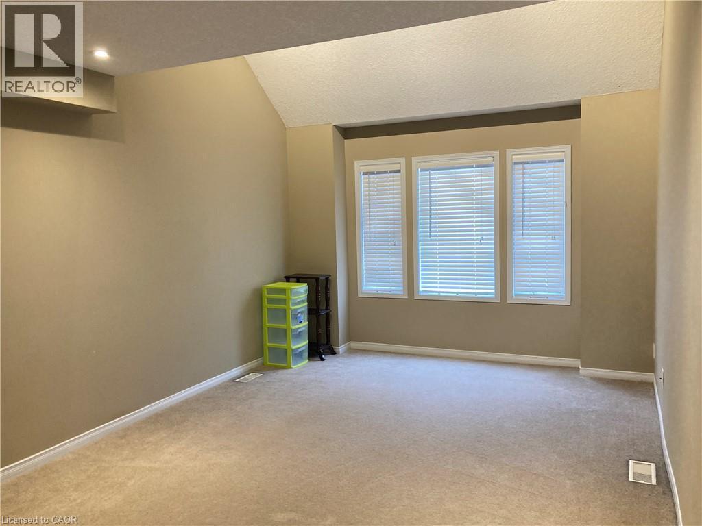 Unfurnished room with light colored carpet, lofted ceiling, and a textured ceiling - 421 White Birch Avenue, Waterloo, ON - Indoor