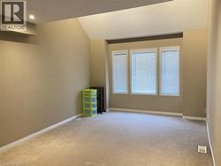 Unfurnished room with light colored carpet, lofted ceiling, and a textured ceiling -