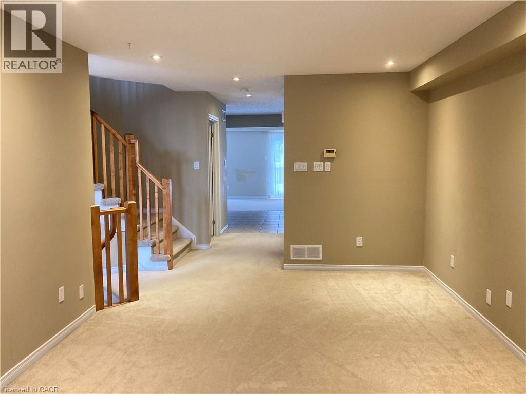 Empty room with light colored carpet, recessed lighting, and stairs - 421 White Birch Avenue, Waterloo, ON - Indoor Photo Showing Other Room